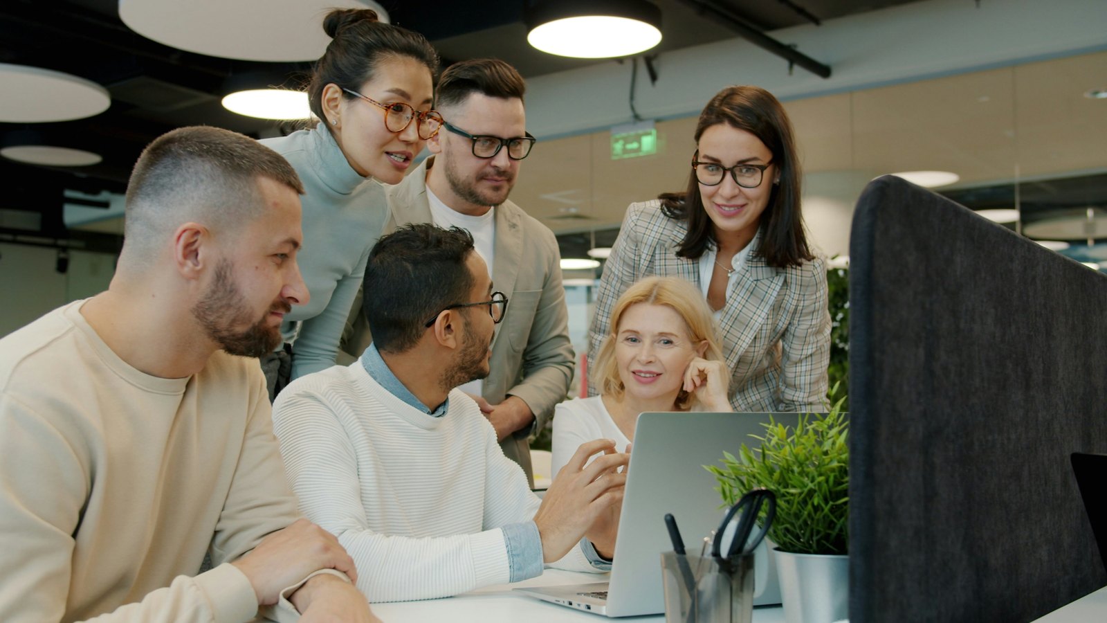 Team gathered around a laptop working through a project together