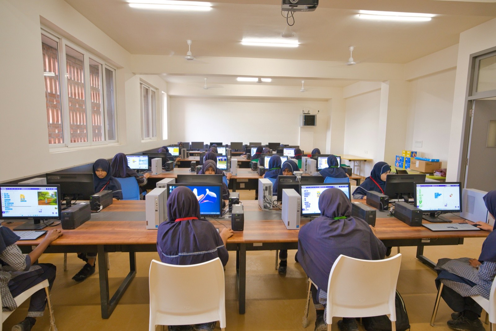 Technical training lab with rows of learners working at computers